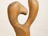 sculpture of a wooden figure on a white pedestal