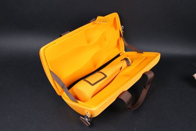 a yellow case with a tool in it on a black surface