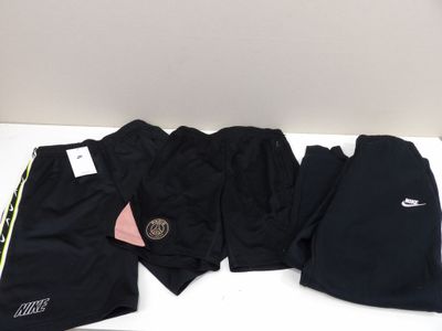 three pairs of nike shorts and a hat are on a table