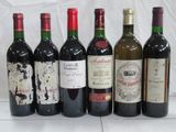 six bouteilles de vin sont alignées sur une table