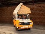 a small yellow van with a tent on top of it