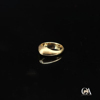 gros plan d'une bague en or sur une surface noire