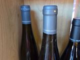 several bottles of wine are sitting on a shelf in a cabinet