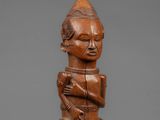 a wooden statue of a man with a hat on his head