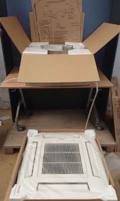 a cardboard box sitting on top of a table next to a air conditioner