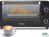 a toaster oven with a cup of coffee next to it