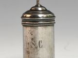 an antique silverplated sugar shaker with a cross on the top