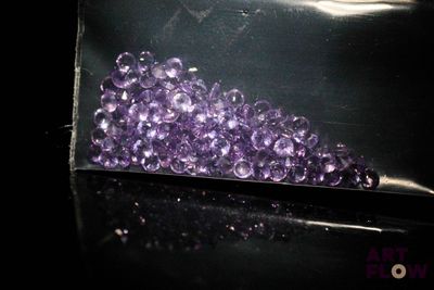 un sachet de perles violettes posé sur une table