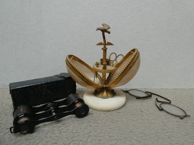 une petite horloge et une paire de lunettes posées sur une table