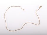 a close up of a gold necklace with a chain on a white background
