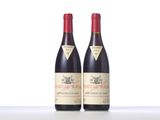 two bottles of red wine sitting on top of a table