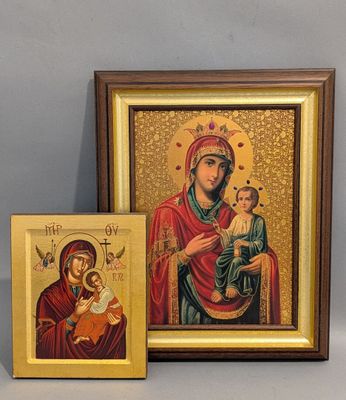 un tableau représentant une femme tenant un enfant dans ses bras, à côté d'une icône encadrée
