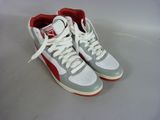 pair of white and red sneakers with red soles on a white surface