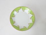 a green and white plate on a white table