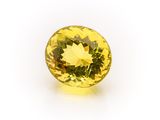 a close up of a yellow sapphire stone on a white surface