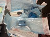 a person holding a bag of medical supplies on a table