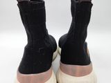 the soles of a pair of black sneakers on a white surface