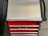a close up of a metal tool box with red drawers on it