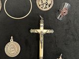 a lot of silver and gold jewelry on a black table