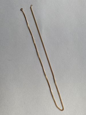 un collier en or auquel est attachée une chaîne