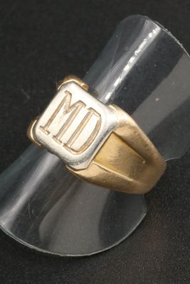 une bague en or sur laquelle sont gravées les lettres « nd »