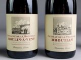 two bottles of red wine sitting next to each other on a table