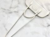 the small white bag is sitting on a marble surface