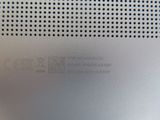 the back side of a silver laptop with a small hole in the middle of it