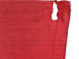 an old red cloth with a hole in the middle of it