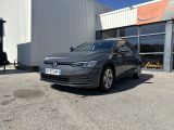 une Volkswagen e-Golf grise garée devant un immeuble