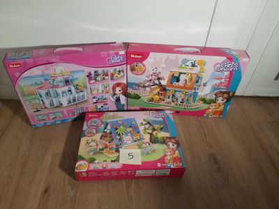 deux boîtes de jouets posées l'une à côté de l'autre sur un plancher en bois