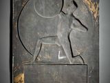 a close up of a metal plaque with a dog on it