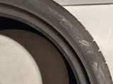 a close up of a tire on a white surface with a shadow on the tire