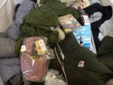 a pile of clothes and other items on a bed