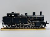 une maquette de train noir posée sur un socle en bois