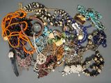 many different types of beaded necklaces on a table