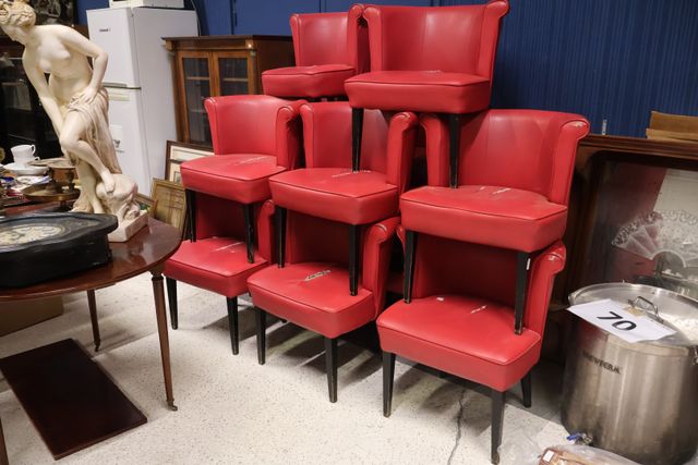Suite de 12 fauteuils en simili cuir rouge, piètement bois noirci...
