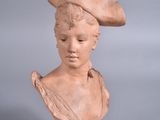 statue d'une femme coiffée d'un chapeau, sur fond gris