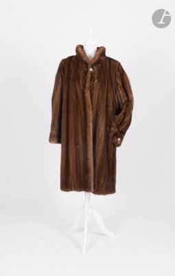 une photo d'un manteau de fourrure marron posé sur un présentoir pour mannequin