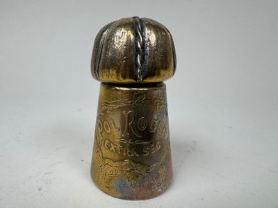 un petit objet métallique sur une surface blanche