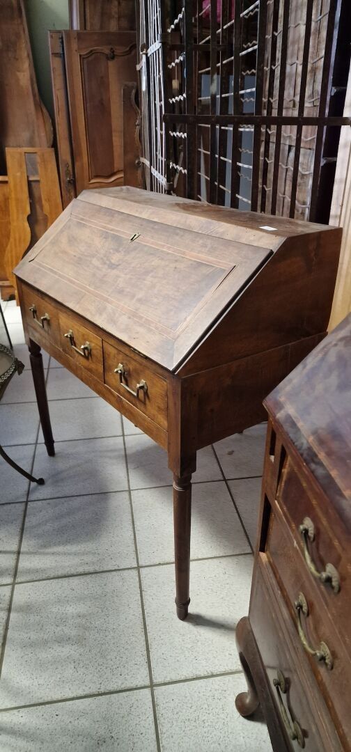 Un bureau de pente en noyer, de style Louis XVI.