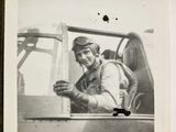an old black and white photo of a man sitting in a plane