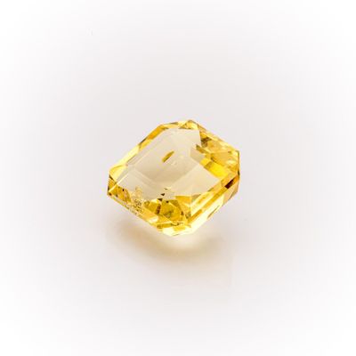 a yellow sapphire stone on a white background
