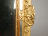 a mirror with a gold frame on a wall