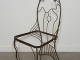 a metal chair that is sitting in the middle of a room