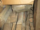 a pile of wood sitting on the floor next to a cardboard box