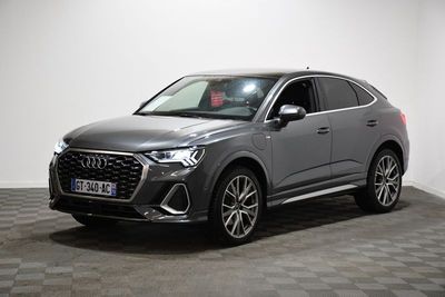 une Audi QX grise garée dans une pièce au sol carrelé