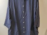 une chemise à rayures bleues et blanches suspendue à un cintre