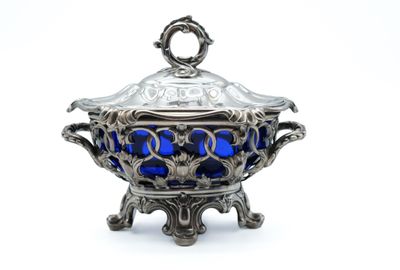 a silver and blue bowl with a lid on a stand
