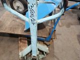 a blue cart with a wheel on it in a warehouse
